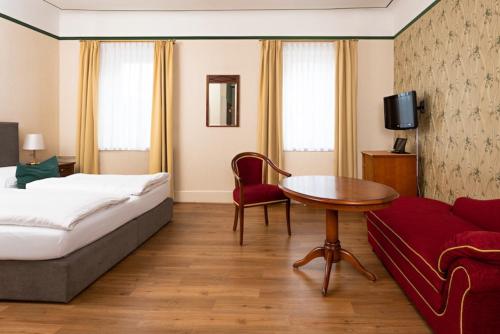 魏玛Boutique-Hotel Amalienhof的酒店客房配有床、桌子和沙发。