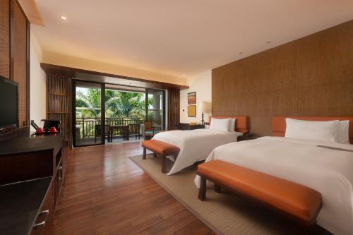 万宁石梅湾艾美度假酒店（三亚机场穿梭巴士+每日免费亲子活动）的酒店客房设有两张床和电视。