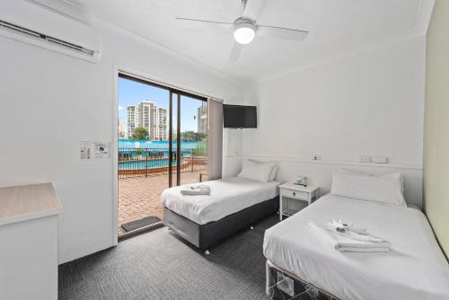 黄金海岸Gold Coast Inn的酒店客房设有两张床和一个阳台。