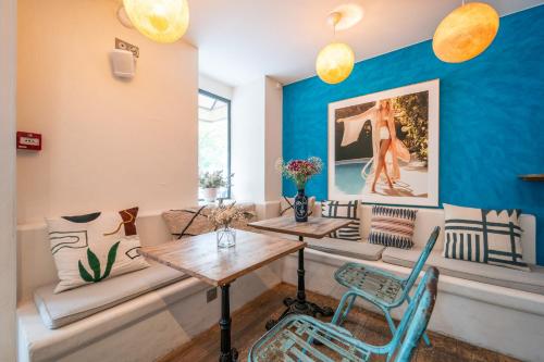 巴黎La Finca Hôtel & Spa的一间设有两张桌子和椅子的房间,以及蓝色的墙壁