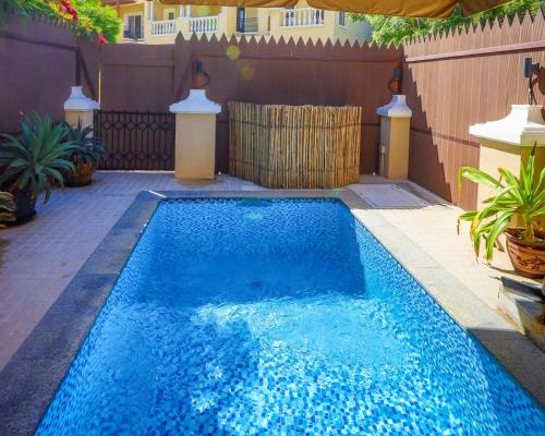 拉斯阿尔卡麦Dar 66 Plunge Pool Resort Townhouses的后院的蓝色小游泳池