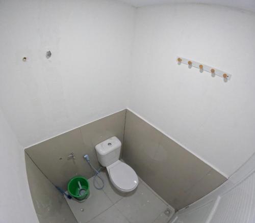 日惹Tamasya Living Malioboro Family Only的白色浴室设有卫生间和绿色桶