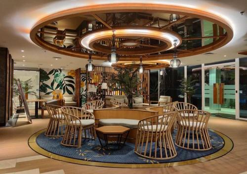 巴厘巴板Astara Hotel Balikpapan的一间带椅子和桌子的房间以及吊灯