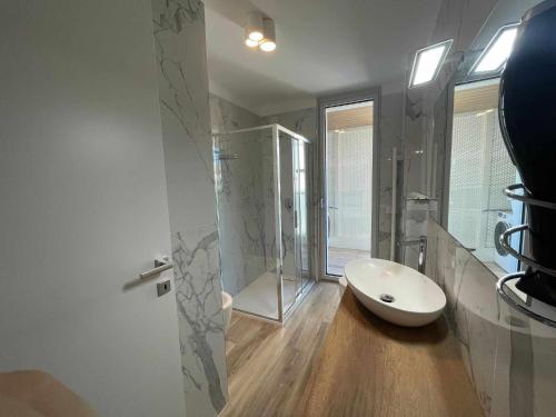 利尼亚诺萨比亚多罗MARE Appartamento 8的浴室配有白色水槽和淋浴。