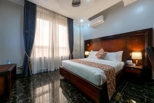 姆巴拉拉Las Vegas Garden Hotel Mbarara的酒店客房设有一张床和一个大窗户