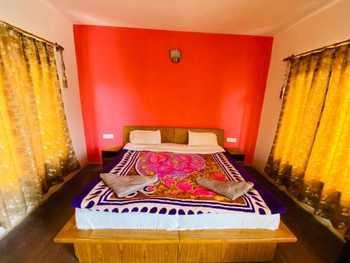 列城曼陀可令花园餐厅旅馆的一间卧室配有一张红色墙壁的床