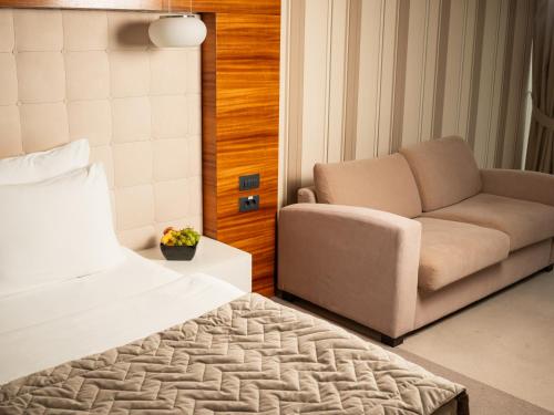 诺维萨德加尔尼中心酒店的一间卧室配有一张床、一张沙发和一把椅子