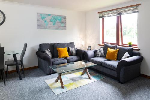邓弗姆林Bothwell Court Apartments的客厅配有两张沙发和一张桌子