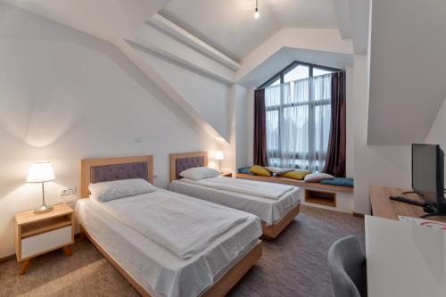 兹拉蒂博尔Apartments Kulturni centar Zlatibor的一间卧室设有两张床和窗户。