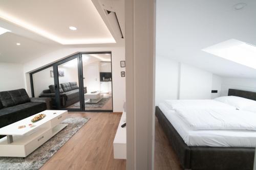 萨拉热窝Luxury Apartments Una Sarajevo的一间卧室设有一张床和一间客厅。