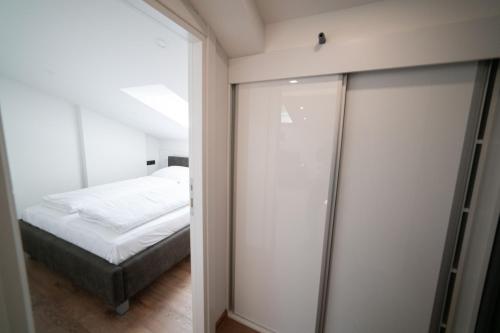 萨拉热窝Luxury Apartments Una Sarajevo的一间卧室设有一张床和一个滑动玻璃门