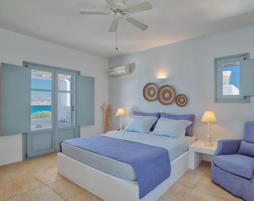 安迪帕罗斯岛Villa Afroditi的一间卧室配有蓝色的床和蓝色椅子