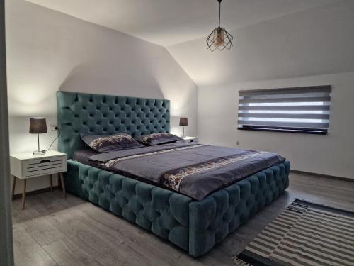 ArcaniCasa Eridav的卧室内的一张大床,上面有蓝色的软垫床头板