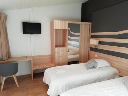 纳雅克VVF Aveyron Najac的一间酒店客房,设有两张床和电视