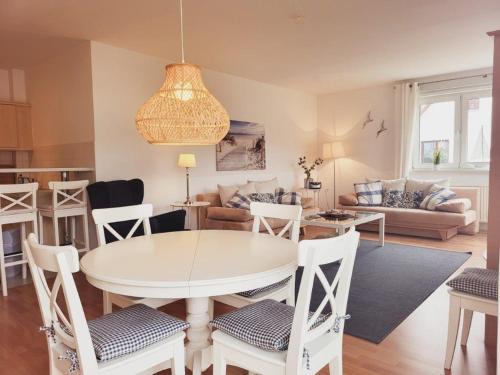 奥斯赛拜-屈隆斯博恩Appartementhaus Ulmenhof的用餐室以及带桌椅的起居室。