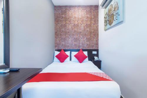 八打灵再也OYO 876 Hotel Sanctuary的一间卧室配有一张带红色枕头的床