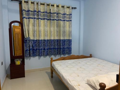 KilinochchiAhi House的一间卧室配有床和窗帘