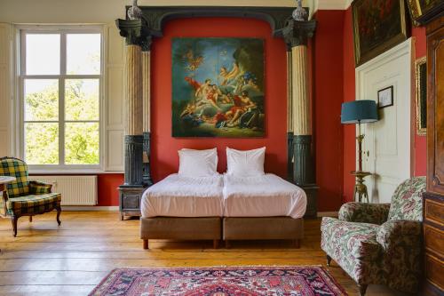 德伯珍斯特肯堡城堡的卧室配有一张床,墙上挂有绘画作品
