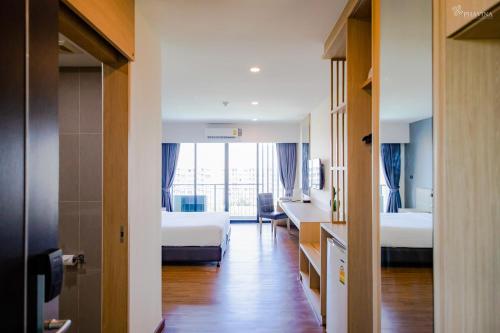 罗勇Phavina Grand Boutique的一间酒店客房,设有两张床和走廊