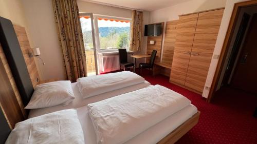 门曾施瓦德Hotel Silberfelsen的酒店客房设有两张床和一张桌子。