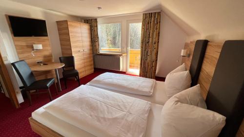 门曾施瓦德Hotel Silberfelsen的酒店客房设有两张床和一张桌子。