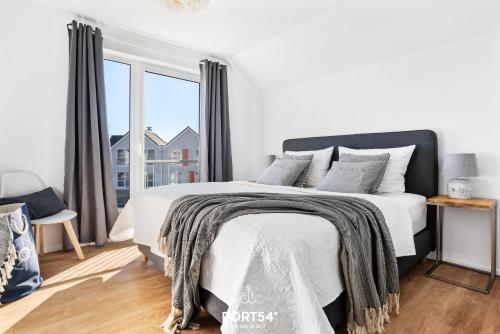 奥尔本尼兹Port Seven的白色的卧室设有床和大窗户