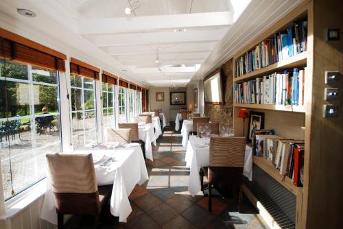 洛亨黑德莫纳齐尔莫霍酒店的一间带桌椅和书籍的餐厅