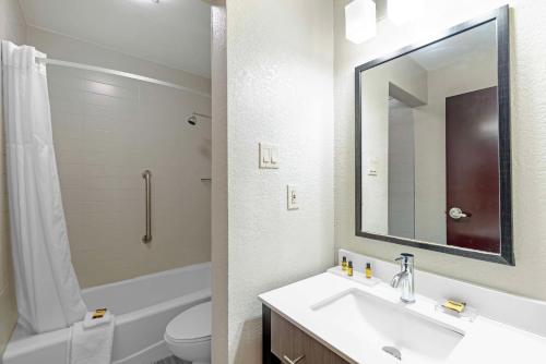 奥斯汀华美达 - 奥斯汀中央酒店的一间带水槽、卫生间和镜子的浴室