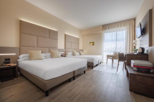 雷诺河畔卡尔代拉拉JR Hotels Gate 7 Bologna的酒店客房设有两张床和一张桌子。