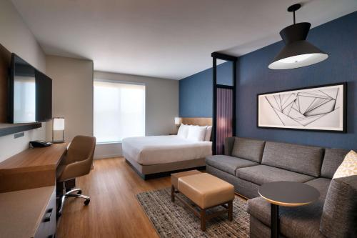 费耶特维尔Hyatt Place Fayetteville/Springdale的酒店客房,配有床和沙发