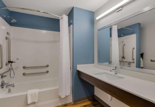 罗阿诺WoodSpring Suites Roanoke的一间带水槽、淋浴和镜子的浴室
