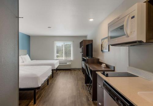 罗阿诺WoodSpring Suites Roanoke的小型酒店客房设有两张床和厨房。