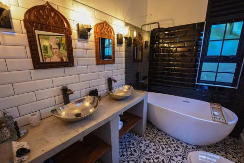 金贾Private Villa at the Source of the Nile的一间带两个盥洗盆和大浴缸的浴室