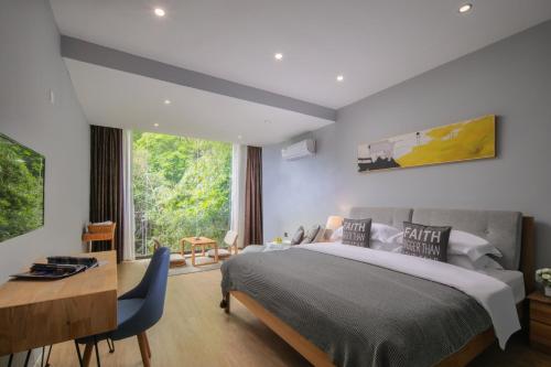 阳朔阳朔伴山墅民宿酒店的一间卧室配有一张床、一张书桌和一个窗户。