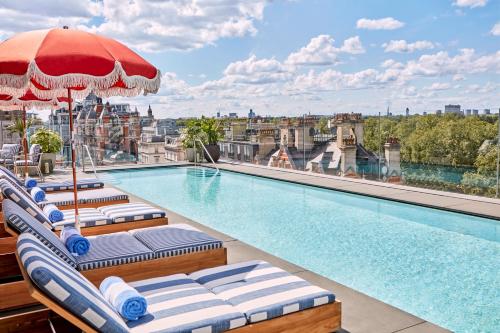 伦敦梅宝尼伯克利酒店的一座带躺椅和遮阳伞的建筑屋顶游泳池