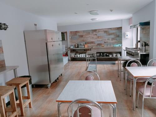 贝尔法斯特贝尔法斯特国际青年旅舍的厨房配有桌椅和冰箱。