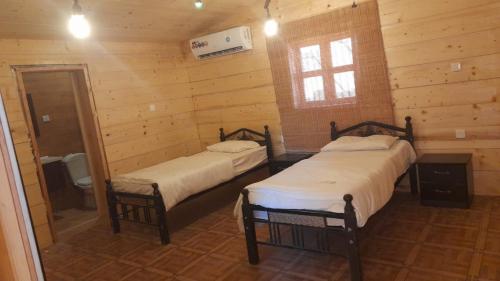 乌姆莱季Royal Tours Cottages的小木屋内带两张床的房间
