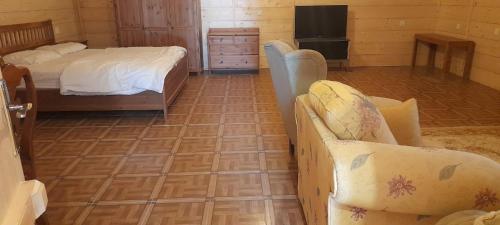 乌姆莱季Royal Tours Cottages的卧室配有1张床和1张沙发,铺有瓷砖地板。