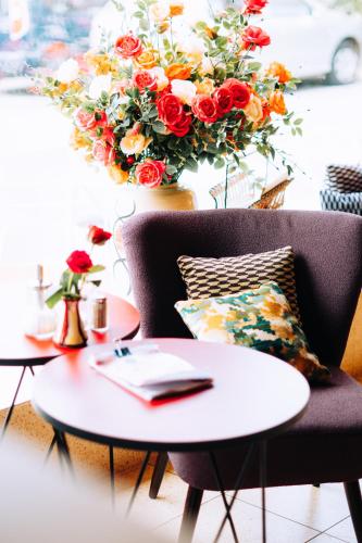 文西德尔Molo Rouge的一间设有两张桌子和一把椅子的房间,并装饰有花卉
