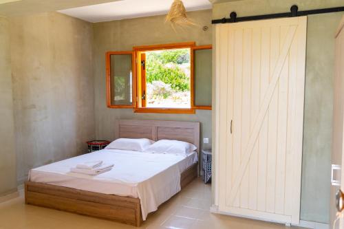 加夫多斯岛Exoristoi Nature Suites的一间卧室设有一张床和一个推拉门