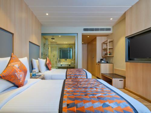 阿姆利则Fortune Inn Heritage Walk Amritsar的酒店客房设有两张床和一台平面电视。