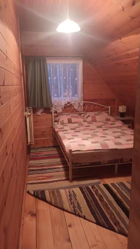 WiżajnyWynajem pokoi Burniszki的小木屋内一间卧室,配有一张床