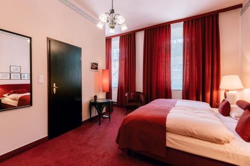 艾恩贝克Hotel Der Schwan的酒店客房,配有床和红色窗帘