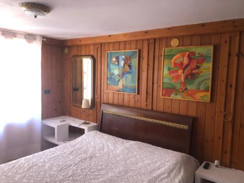 贝尼萨Bonito apartamento villa Joya的一间卧室设有木墙、一张床和镜子