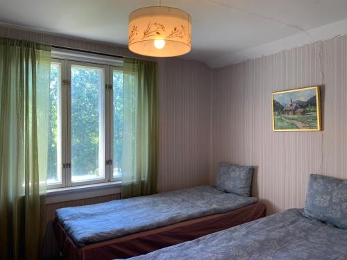 KumlingeUppleva att bo på en gammal gård的一间卧室设有两张床和窗户。