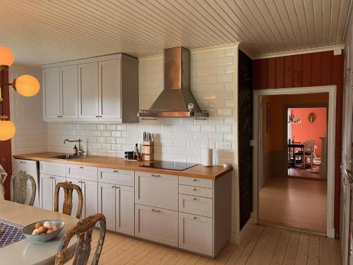 MalmköpingHerrgårdsflygel mitt i Sörmland的厨房配有白色橱柜和炉灶。