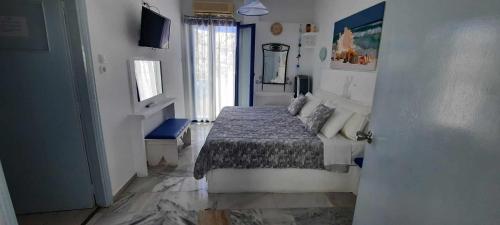 纳克索乔拉Doron Hotel Delfini的一间卧室设有床、窗户和门