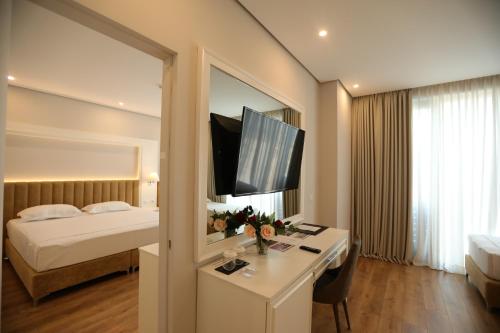 格勒姆高级海滩酒店的酒店客房配有一张床和一张书桌及一台电视