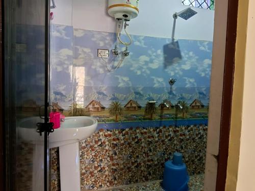 巴德里纳特Badrinath Jb Laxmi hotel的一间带水槽和墙壁的浴室