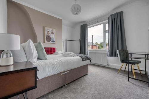 诺丁汉Stylish Home - Fast Wi-Fi-FREE Parking的一间卧室配有一张带书桌的床和窗户。